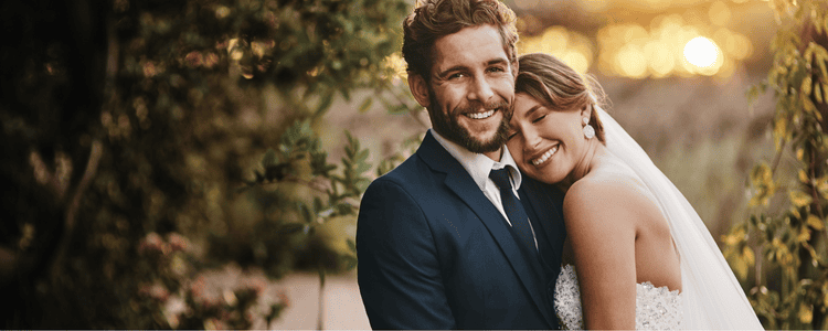 A bride and groom smile at camera
